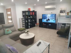 a living room with a couch and a tv at Dubbo Farm in Dubbo