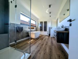 a bathroom with two sinks and a tub and a shower at Bergkultur Sauerland in Medebach +95 photos