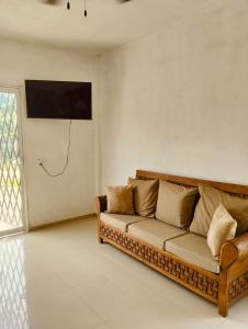 a living room with a couch and a television on the wall at Casa Imox in Bacalar