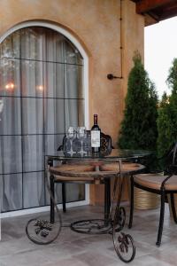 a table with glasses and a bottle of wine on it at KISLOV Vineyard Boutique Hotel in Hagimus