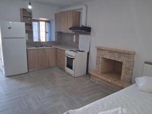 a kitchen with a white stove and a fireplace at Makri Guest House in Livanates