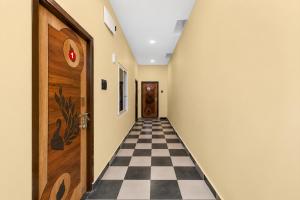 a hallway with a checkerboard floor and a door at Hotel O Shadnagar Formerly Sri Jogulamba Residency in Bālānagar