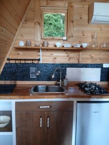 a kitchen with a sink and a stove at A-frame с видом на горы in Kokotauri +2 photos