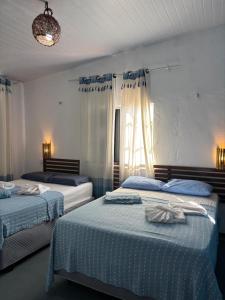 a bedroom with two beds and a window at Casa Cochilo na Rede in Beberibe +29 photos