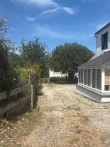 a yard next to a house with a fence at Idéalement placée in Santec