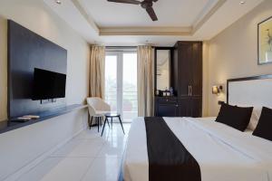 a hotel room with a large bed and a flat screen tv at Super Townhouse Oak Udyog Vihar in Gurgaon