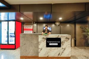 a man is standing behind a counter in a lobby at Super Townhouse Oak Udyog Vihar in Gurgaon