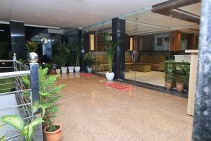 a lobby with a lot of potted plants in a building at Hotel New JMK in Katra
