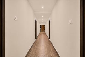 a hallway with white walls and wood flooring at Hotel O Visakhapatnam Railway Junction Formerly Kesava Residency in Visakhapatnam