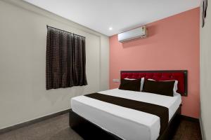 a bedroom with a large bed with a red headboard at Hotel O Visakhapatnam Railway Junction Formerly Kesava Residency in Visakhapatnam