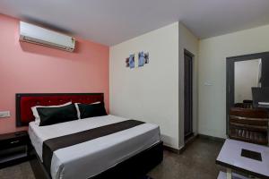 a bedroom with a large bed with a red headboard at Hotel O Visakhapatnam Railway Junction Formerly Kesava Residency in Visakhapatnam