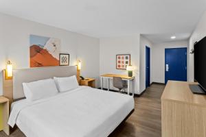 a bedroom with a white bed and a desk at Spark By Hilton Prestonsburg in Prestonsburg +54 photos