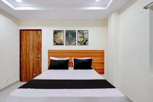 a bedroom with a bed and a wooden headboard at Hotel O Madurawada Formerly IT Sez in Visakhapatnam