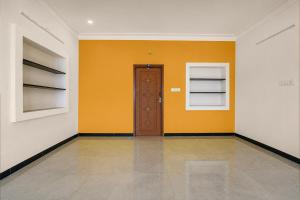 a room with a door and a yellow wall at Collection O Anbu Nagar Coimbatore in Coimbatore