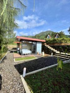 a house with a pavilion in the middle of a yard at Kayana Capsul Dieng in Kejajar