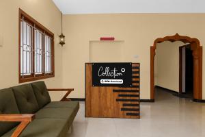 a living room with a couch and a sign at Collection O Anbu Nagar Coimbatore in Coimbatore