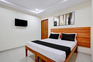 a bedroom with a bed and a tv on the wall at Hotel O Madurawada Formerly IT Sez in Visakhapatnam