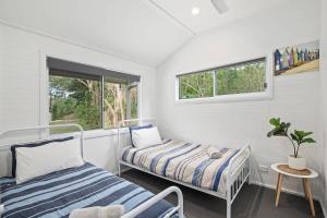 a room with two beds and a window at The Palm Cabin 2 in Mylestom
