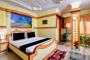 a bedroom with a bed with a painting on the wall at Hotel Shree Krishna in Keonjhargarh