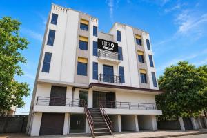a tall white building with a sign on it at Hotel O Sabarmati Ashram Ahmedabad Formerly Red Apple in Ahmedabad