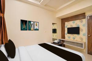 a bedroom with a bed and a flat screen tv at Hotel O Sabarmati Ashram Ahmedabad Formerly Red Apple in Ahmedabad +23 photos