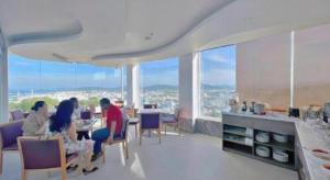 a group of people sitting at a table in a room with windows at Maison Hotel Phu Quoc in Phú Quốc