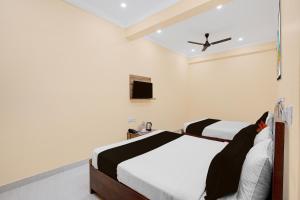 a bedroom with two beds and a tv at Super Collection O Yeshvantpur Railway Junction Formerly Sasthi Inn in Bangalore