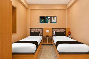 two beds in a small room with two at Collection O Rajgir Railway Station Formerly Hotel Swastik in Ekangar Sarai
