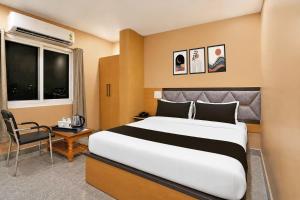 a hotel room with a large bed and a chair at Collection O Rajgir Railway Station Formerly Hotel Swastik in Ekangar Sarai +30 photos