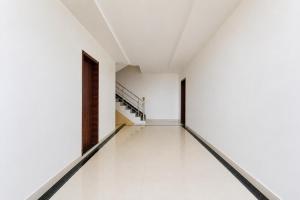 an empty corridor in a white building with a door at Collection O Rajgir Railway Station Formerly Hotel Swastik in Ekangar Sarai