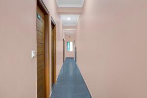a hallway with blue flooring in a house at Super Collection O Yeshvantpur Railway Junction Formerly Sasthi Inn in Bangalore