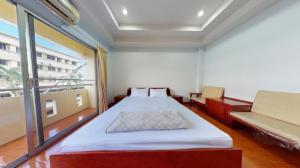 a bedroom with a bed and a large window at Chanthanee Hotel in Ban Chamun (2)