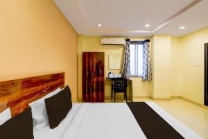 a hotel room with a bed and a desk at Super Hotel O AMR Planet Mall Hyderabad Formerly R Square in Maula Ali