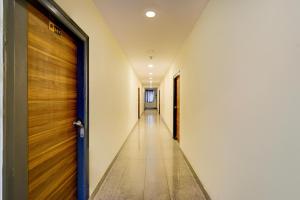 an empty hallway with a wooden door and a corridor at Super Hotel O AMR Planet Mall Hyderabad Formerly R Square in Maula Ali