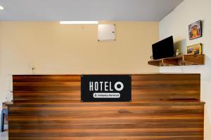 a hotel sign on top of a wooden wall at Super Hotel O AMR Planet Mall Hyderabad Formerly R Square in Maula Ali
