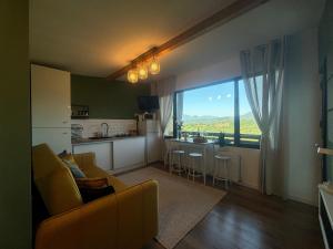 a living room with a couch and a kitchen with a large window at Casa Tamy Bran in Sohodol