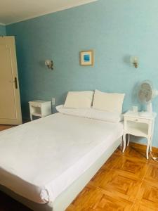 a large bed in a room with a blue wall at La Bienvenue in Tourtrol