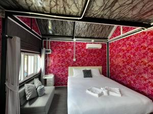 a bedroom with a bed and a red wall at Siriwan boutique hotel in Ban Met Nang Chi +7 photos