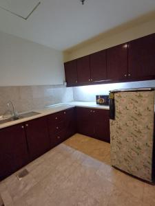 a kitchen with wooden cabinets and a refrigerator at Home Time Square Residence in Kuala Lumpur
