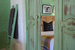 a bedroom with a bed and a green wall at Dennehof Karoo Guesthouse in Prince Albert