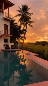 a pool in front of a house with a palm tree at Navi - Boutique Hotel - Adults Only in Ahangama