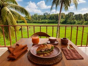 a table with a plate of food and a sandwich on it at Navi - Boutique Hotel - Adults Only in Ahangama