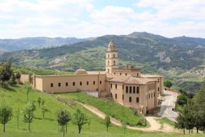 a large building on a hill with a tower at La Casa di Anna'80 in SantʼArcangelo