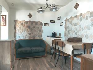 a dining room with a green couch and a table at La Casa di Anna'80 in SantʼArcangelo