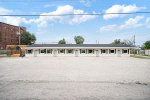 an empty parking lot in front of a white building at Cashmere Private Studio Cozy Chic Escape in Kokomo