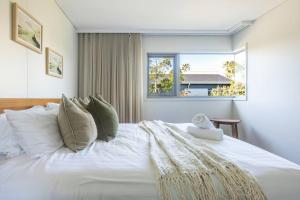 a bedroom with a large white bed with a window at 3BR Golfside Villa | Pools, Tennis & Relaxation in Magenta +57 photos