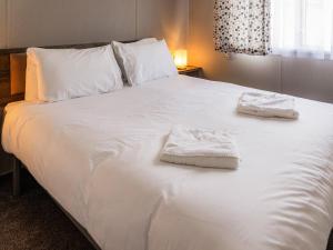 a large white bed with two towels on it at Luna - Ukc9719 in Aston