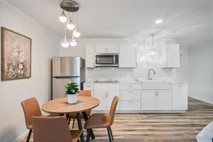a kitchen with white cabinets and a table with chairs at Cashmere Private Studio Cozy Chic Escape in Kokomo