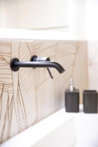 a bathroom sink with a faucet on a wall at Bosa Centro Rooms in Bosa