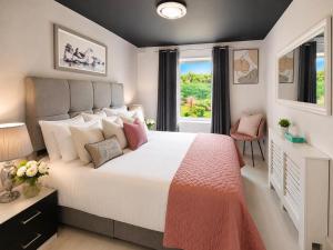 a bedroom with a large white bed and a window at SeaView Apartment Suite in Cobh